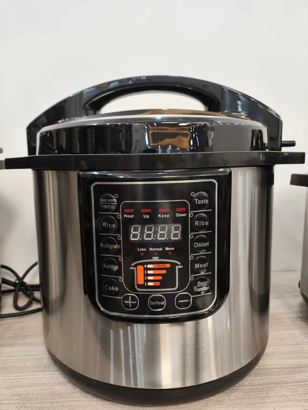 Stainless electric pressure cooker with black lid and front digital program panel