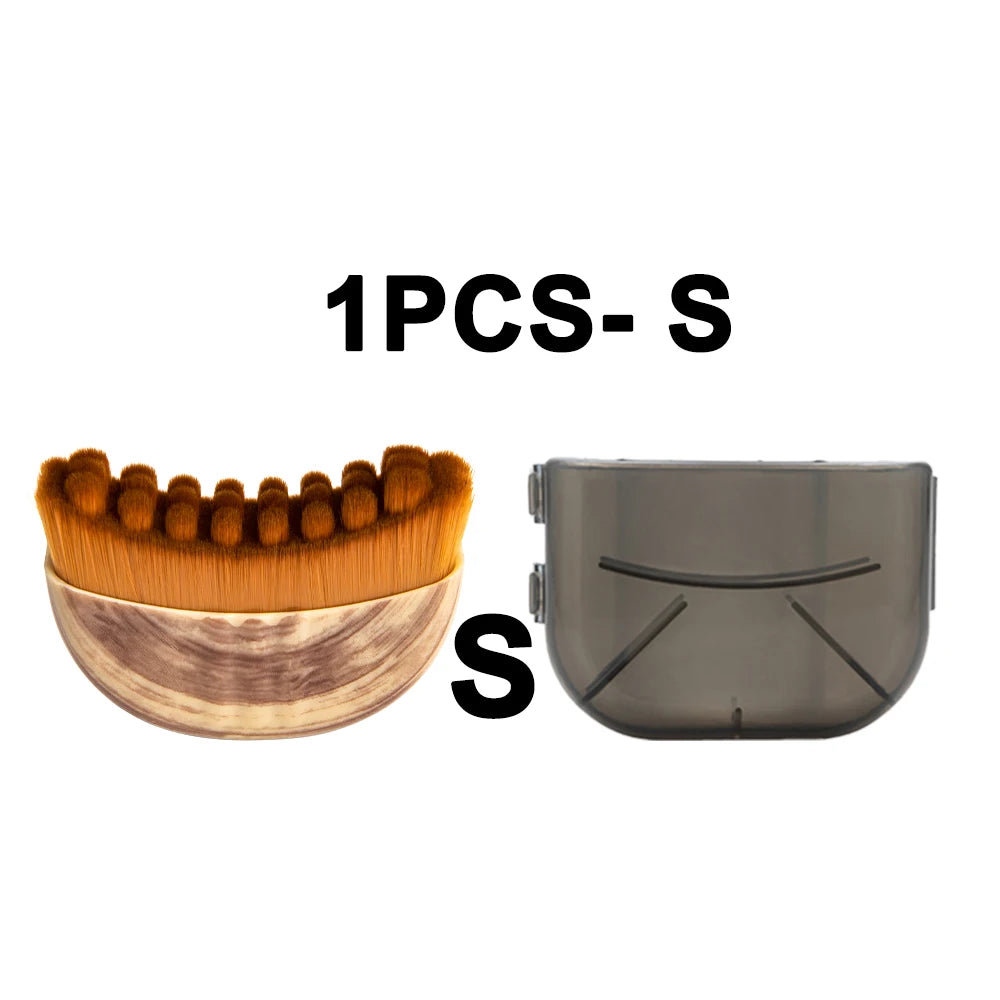 Small oval face massage brush with brown bristles, wood-grain handle, and a transparent grey protective cover.