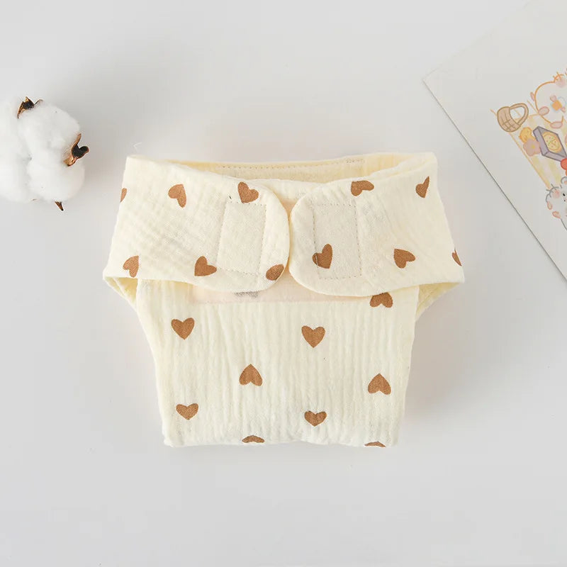 Cream-colored muslin baby diaper with brown heart print, soft fabric baby care essential with Velcro closure.