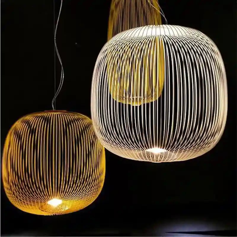 Three round wire pendant lights with glowing bulbs, featuring a cage-like structure against a black background.