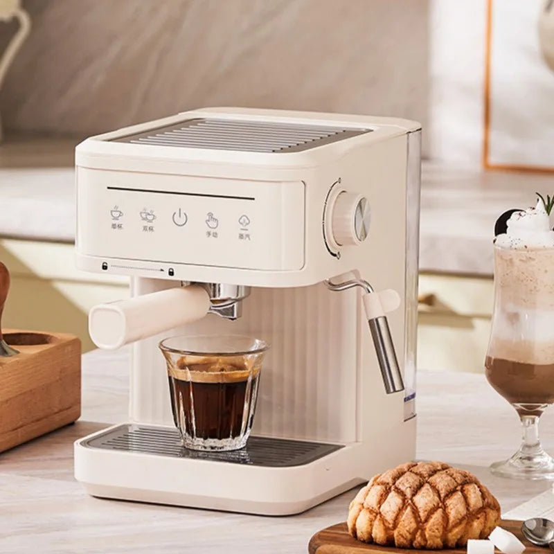 Compact cream-colored espresso machine with steam wand, portafilter, and digital touch controls on a kitchen counter.