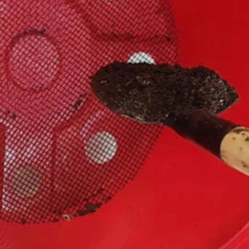 Close-up of black mesh pot drainage screen over pot soil and drainage hole