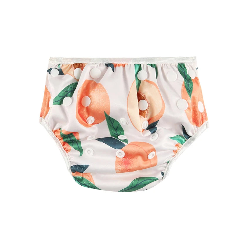 Reusable baby swim diaper with adjustable snaps and cute peach print, white background. Eco-friendly baby care essentials.