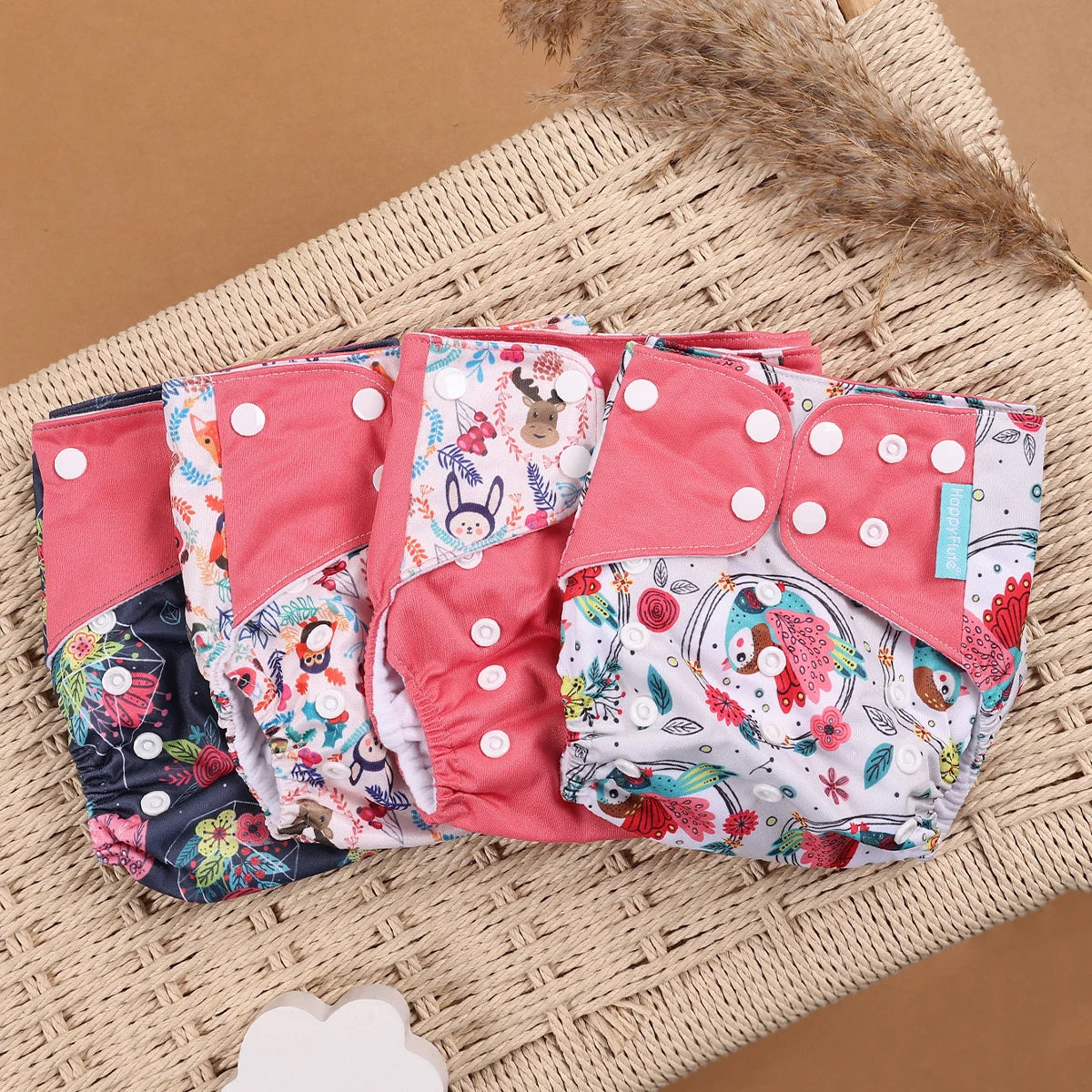 Happy Flute adjustable cloth diapers with colorful animal prints and pink snap closures for eco-friendly baby care.