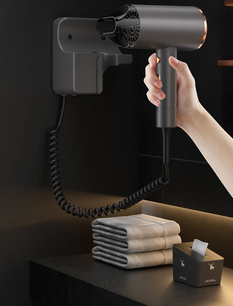 Grey 1600W wall-mounted hair dryer with coiled cord, sleek cylinder design, and drill-free mount for hotel bathrooms.