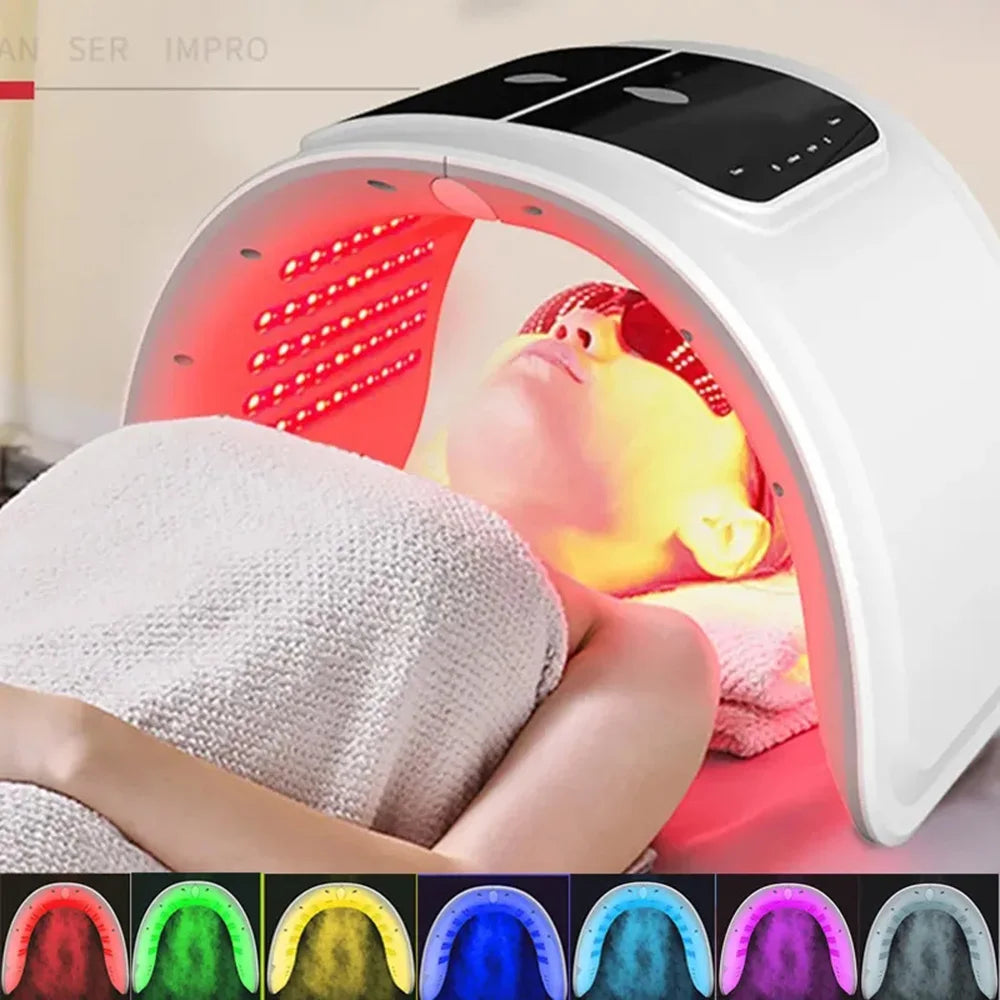 White arched LED facial rejuvenation machine with red light therapy over a person wearing protective eyewear.