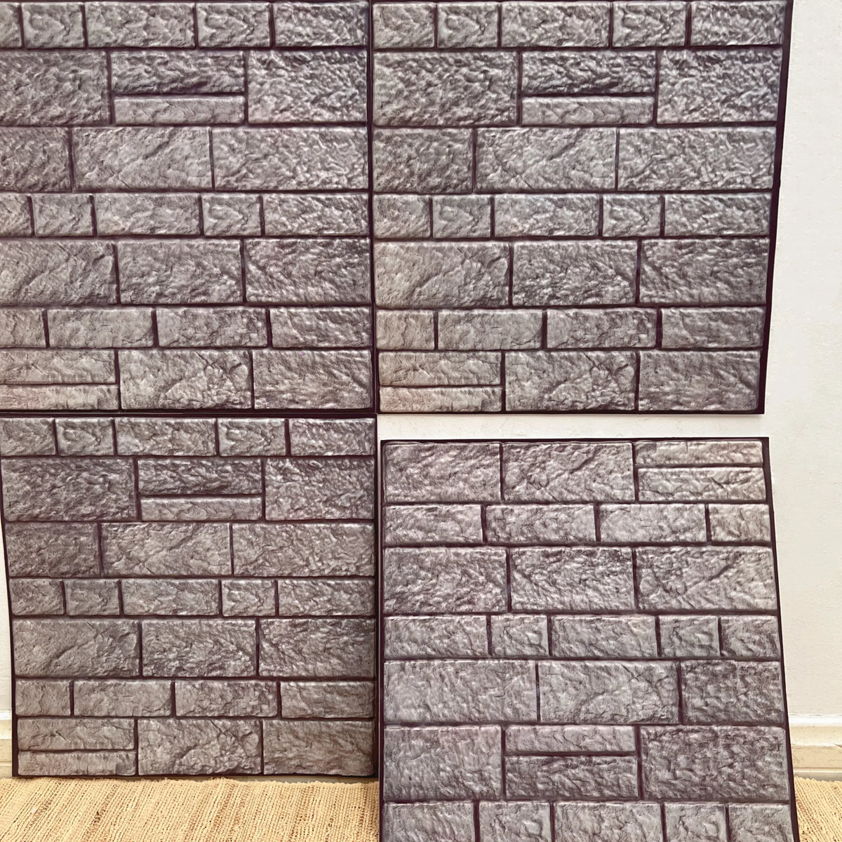 Peel-and-stick faux stone brick backsplash tiles in cool gray and white