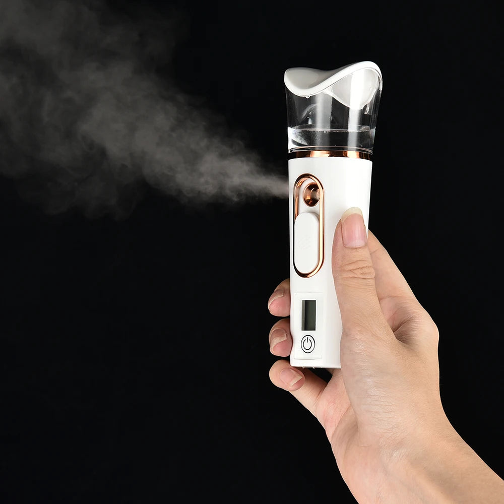 Portable white and rose gold nano facial mister spraying cool hydrating mist for skin care on black background.