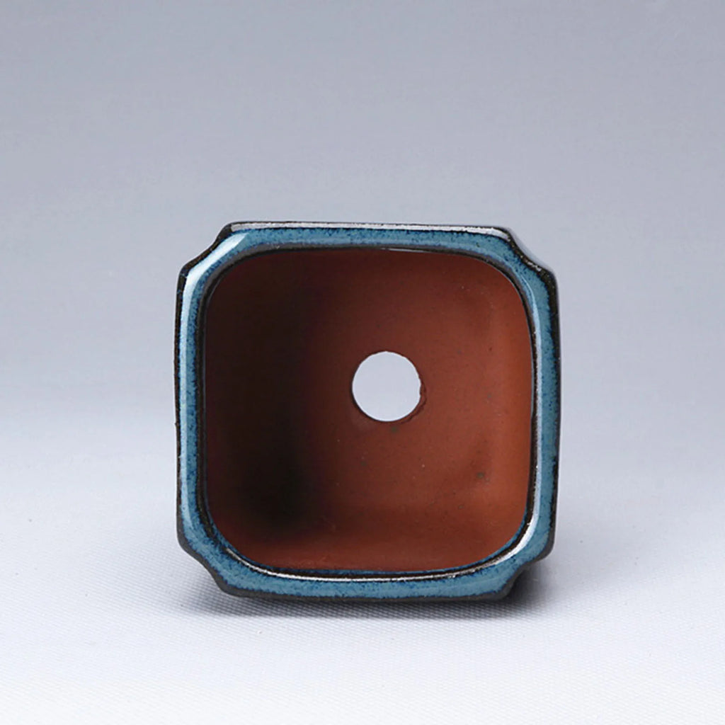 Blue glazed ceramic pot end view showing terracotta interior and vent hole