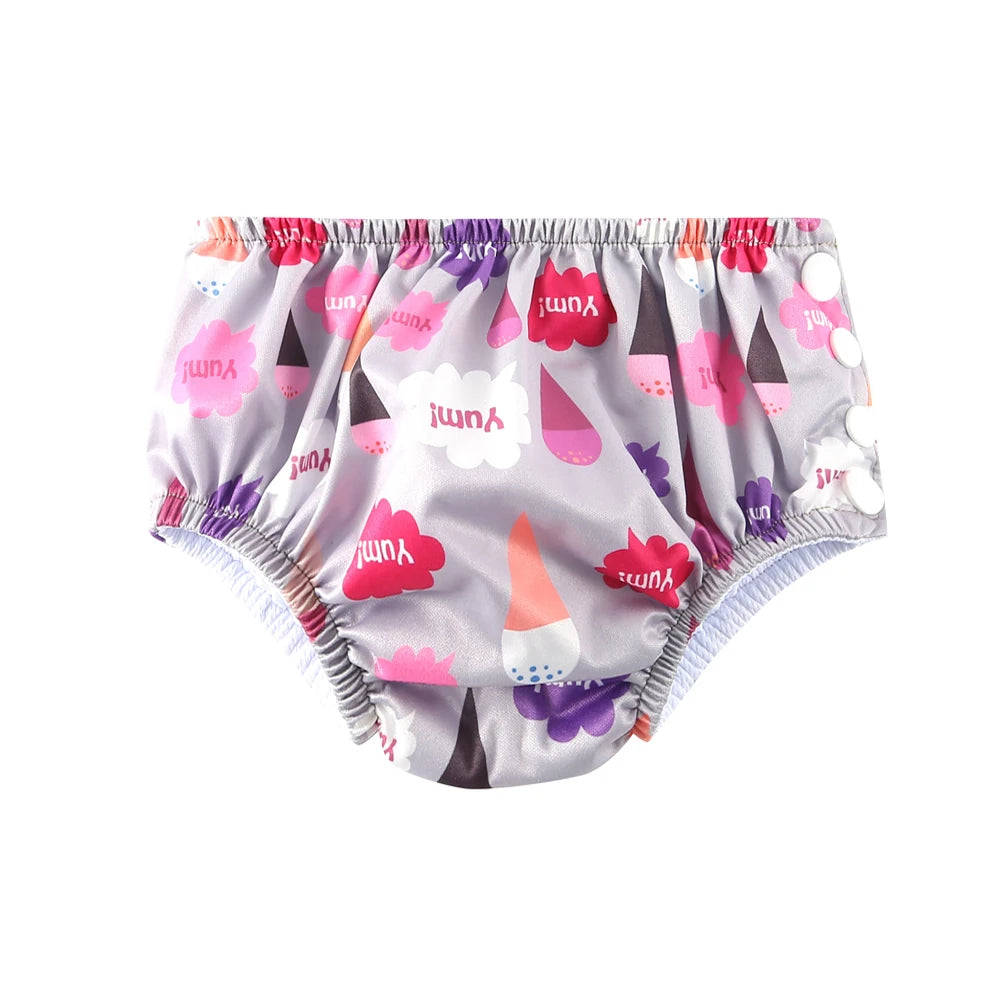 Reusable baby swim diaper in grey with pink ice cream and "Yum!" speech bubble print, side snap closure.