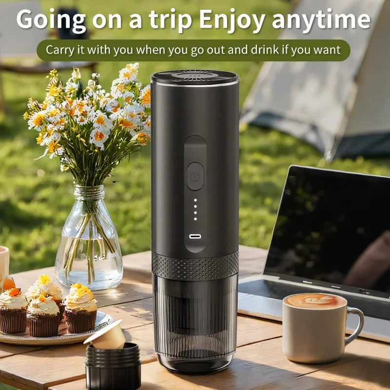 Portable matte black electric espresso maker with USB-C charging on an outdoor camping table.