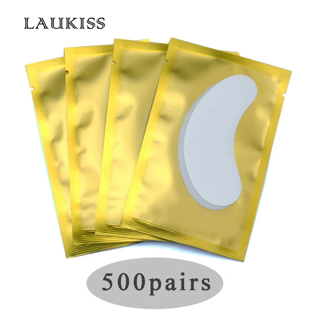White gel under-eye patches for lash extensions in individual gold foil packets, professional beauty supply.
