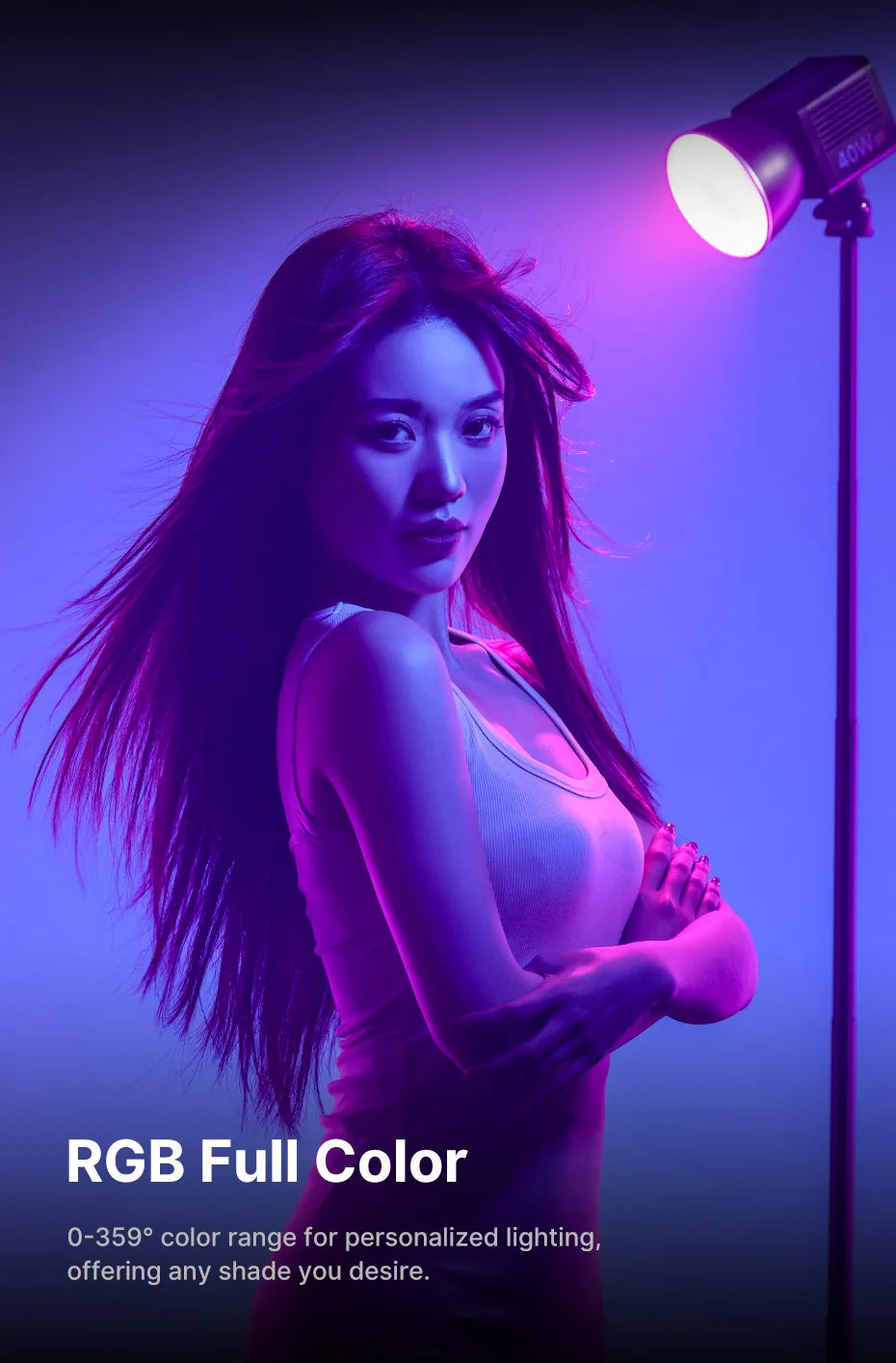 RGB LED studio light on a stand casting purple and blue light on a woman with flowing hair.