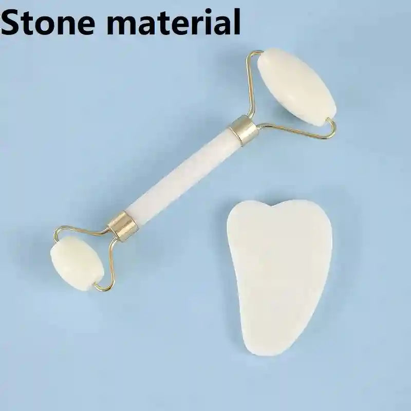 White stone facial roller and heart-shaped gua sha scraping tool with gold-tone hardware on a blue background.