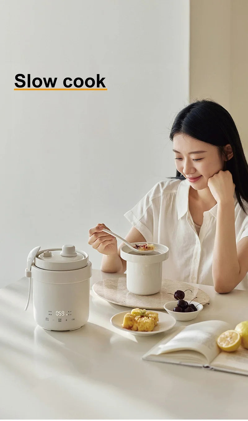 White mini electric rice cooker on table with lid and serving bowls
