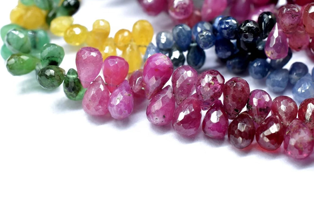 Close-up of pink and dark blue faceted drop beads, with mixed green/yellow beads