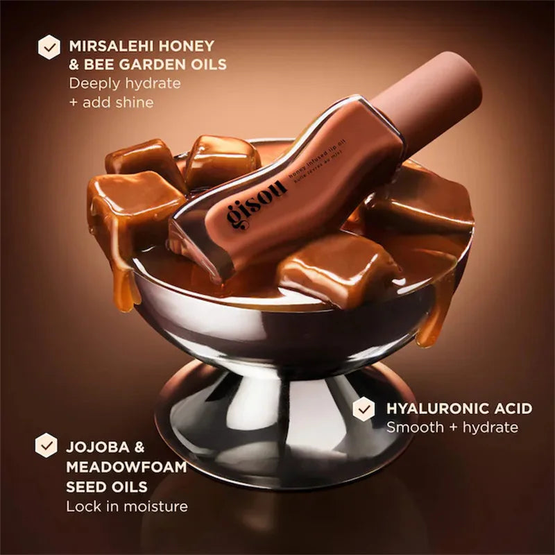 Gisou honey infused lip oil in a glossy plum shade, featured with honey-drizzled cubes for deep hydration and shine.