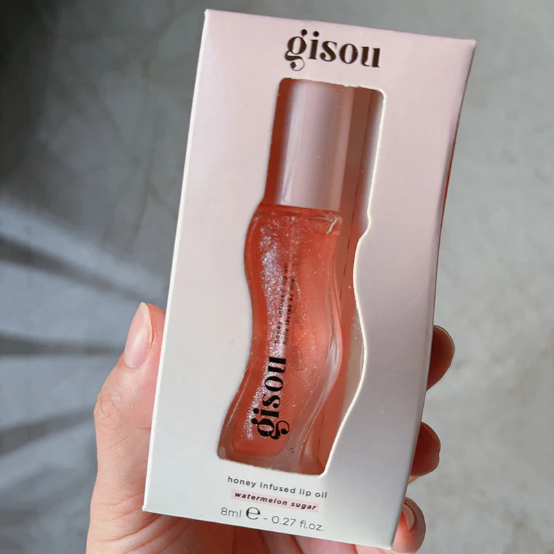 Gisou Honey Infused Watermelon Sugar Lip Oil in box, sheer coral shimmering plumping lip gloss treatment.