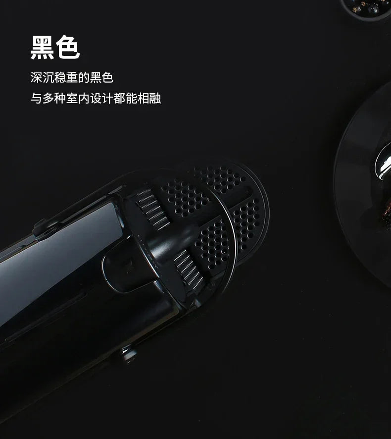 Top-down view of a sleek, matte black compact coffee maker with a textured drip tray and minimalist design.