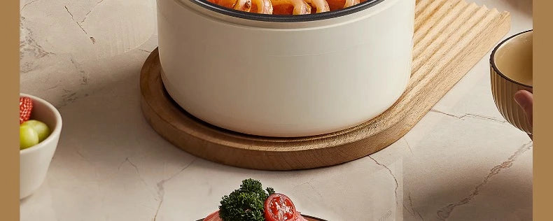 Electric non-stick cooking pot base with white inner pot on a round wooden stand