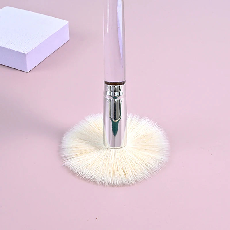 Soft white facial cleanser brush with clear handle for skin care, face mask application, and gentle pore cleansing.