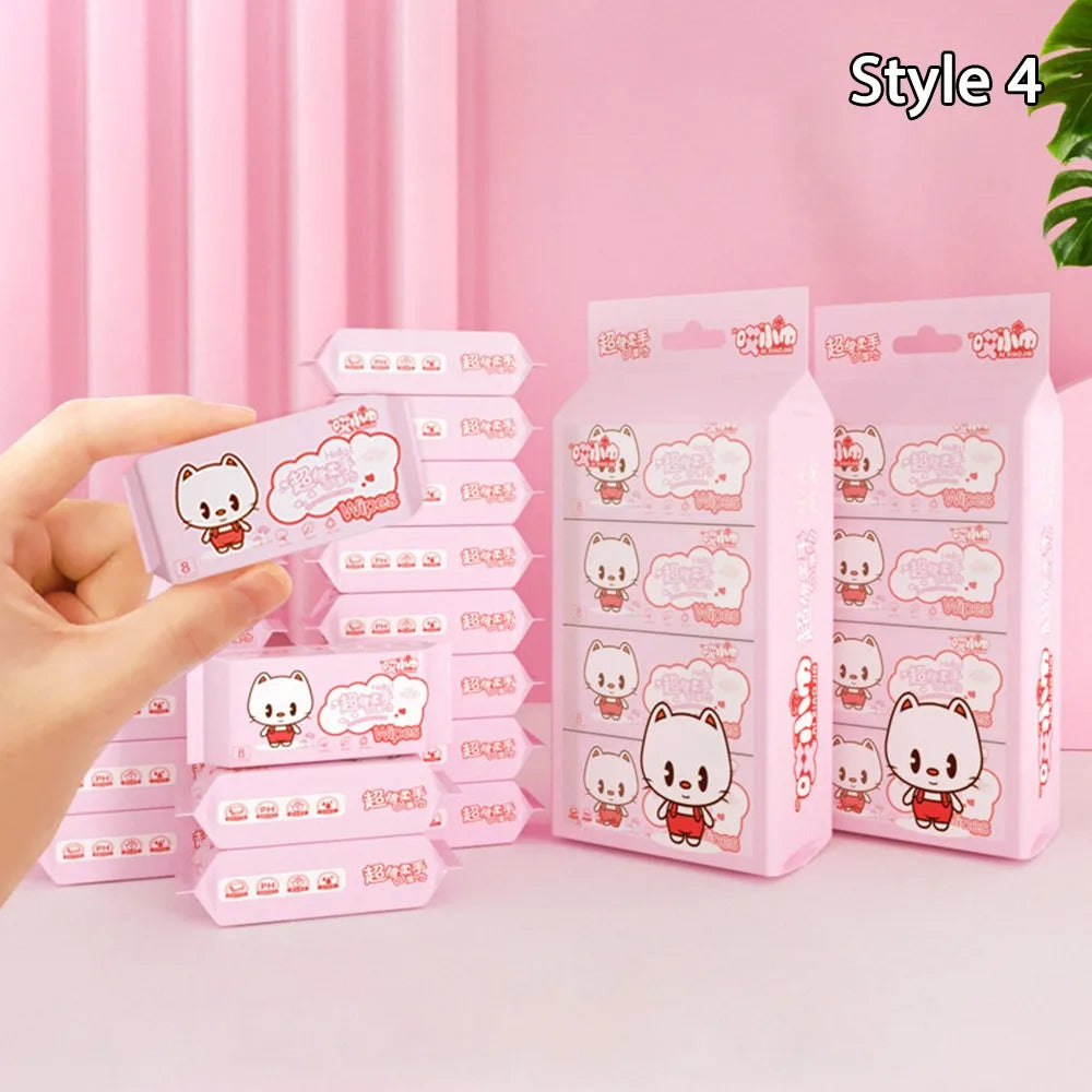 Hand holding pink baby care wipes with cute cat design, featuring small packs in various stacked quantities.