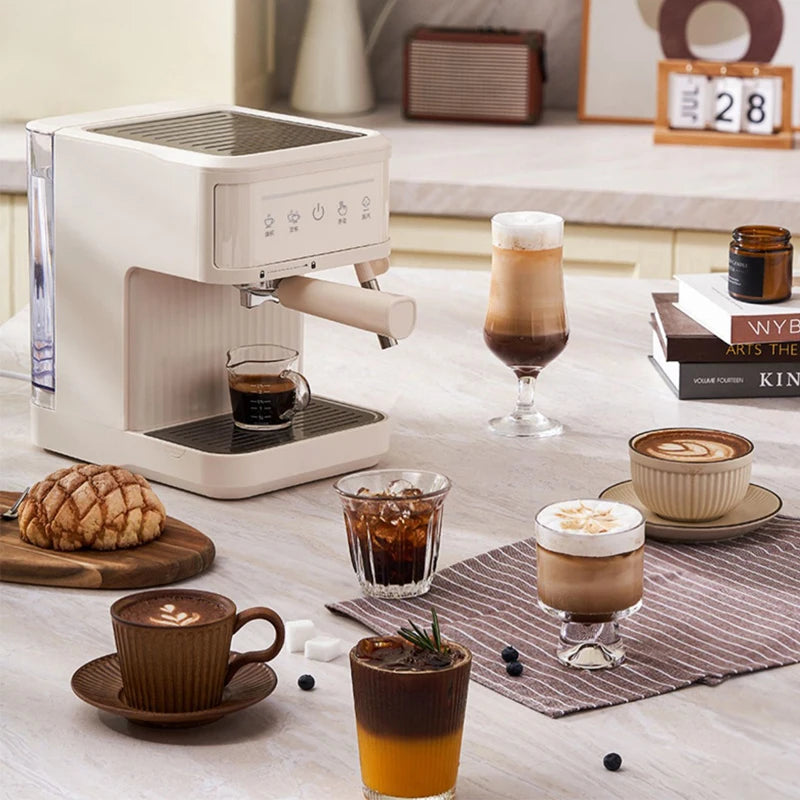 Cream-colored compact espresso coffee machine with digital touch panel on a kitchen counter with various coffee drinks.