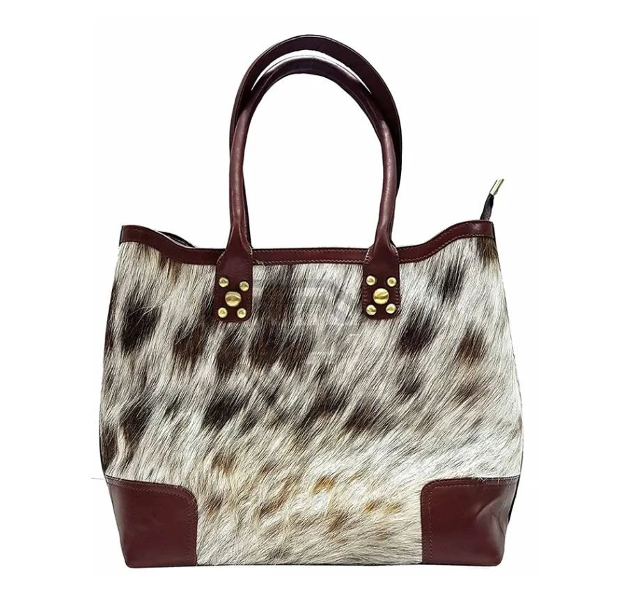 Handmade cowhide leather tote bag with brown fur pattern, maroon leather accents, and brass stud details.