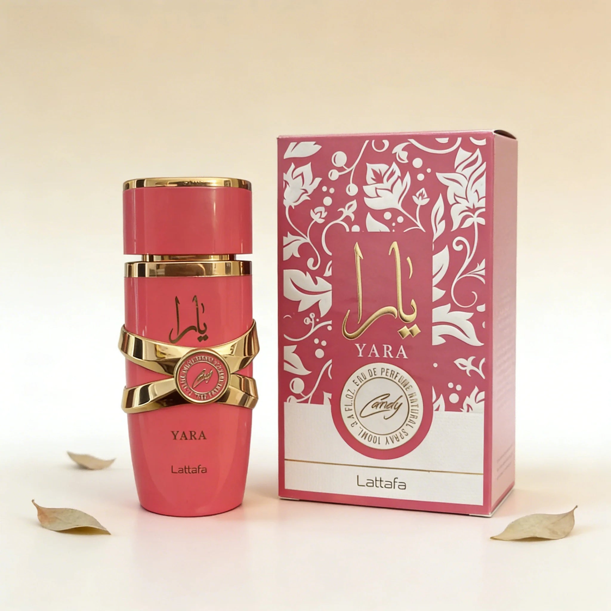 Lattafa Yara Candy perfume bottle and box in vibrant pink with gold accents, featuring a floral design on packaging.
