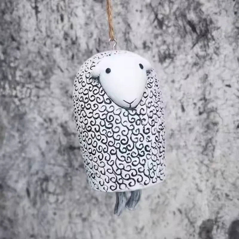 Cute resin sheep wind chime for rustic garden decor. Black and white hanging animal bell ornament for outdoor spaces.