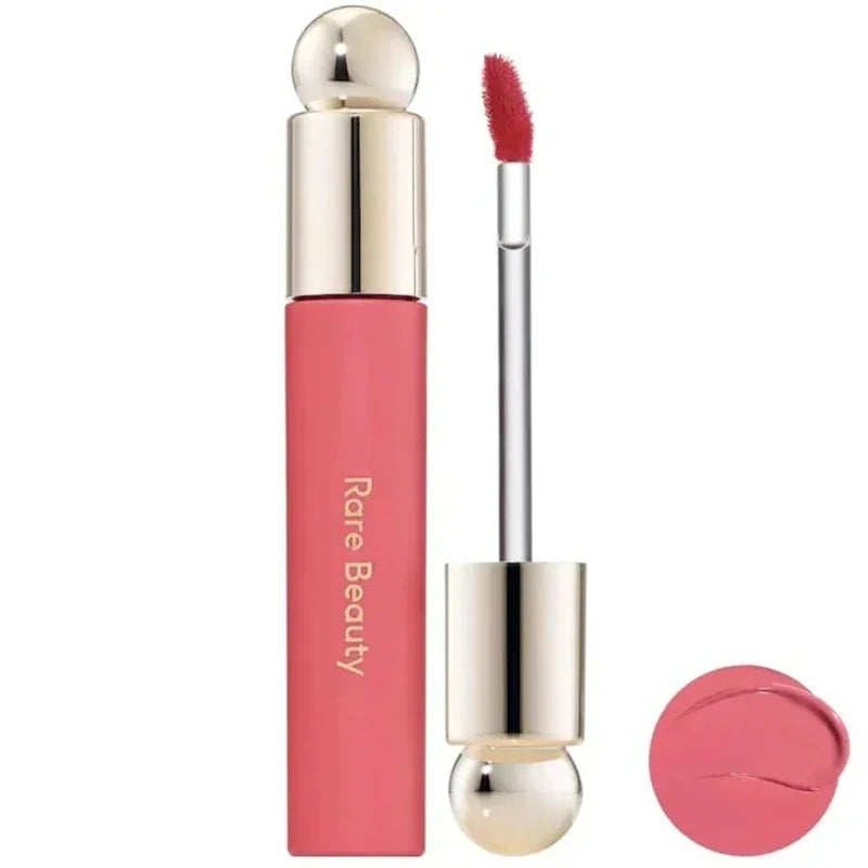 Rare Beauty Soft Pinch Tinted Lip Oil in a pink shade with gold cap, applicator wand, and creamy lip gloss swatch.
