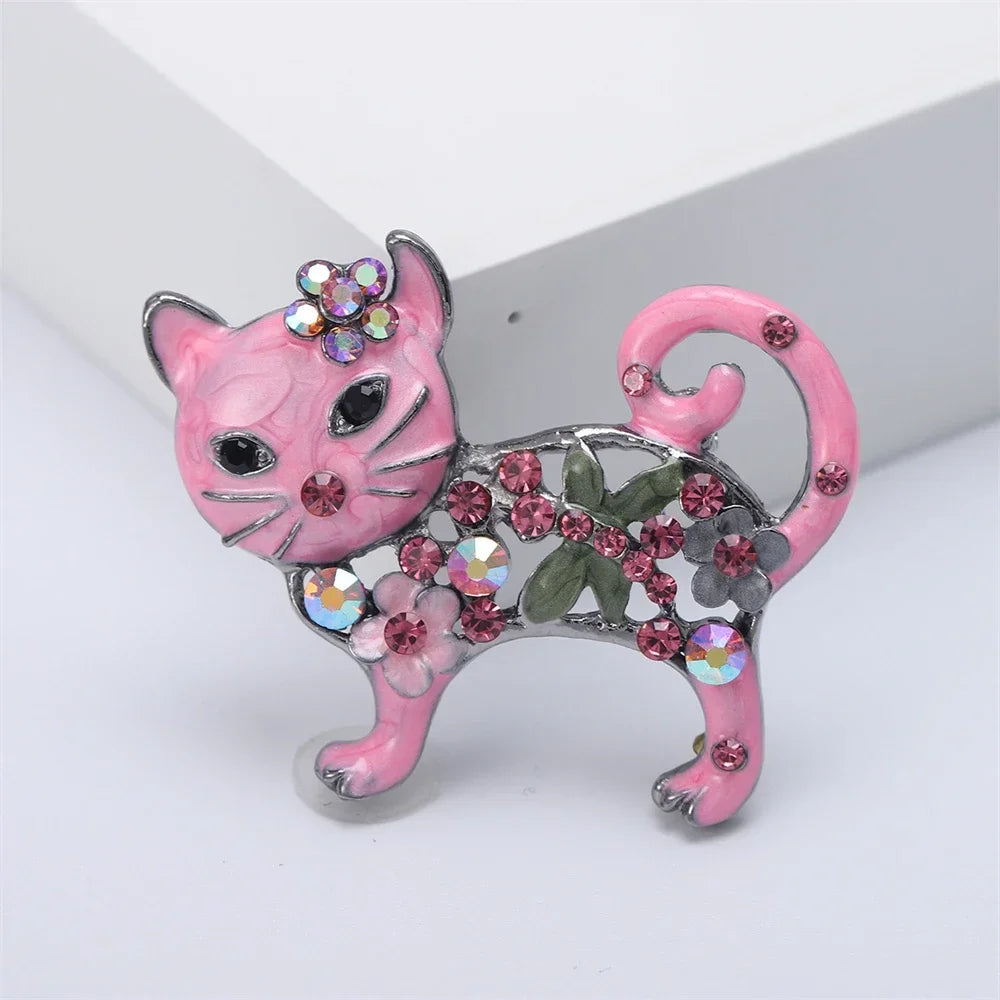 Pink enameled cat brooch with sparkling crystals and floral accents, perfect as a stylish gift for pet lovers.
