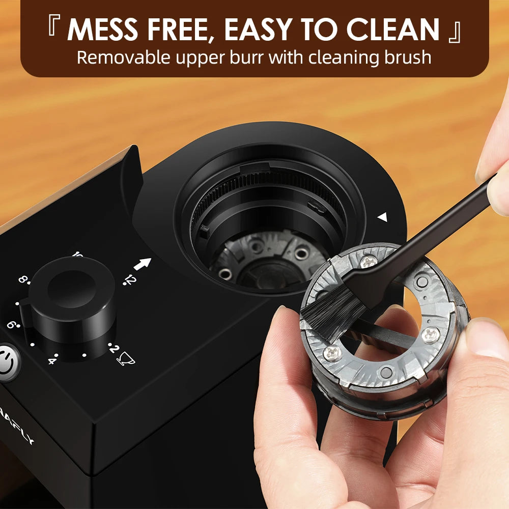 Cleaning a black HAFELE burr coffee grinder with a brush and removable upper burr.