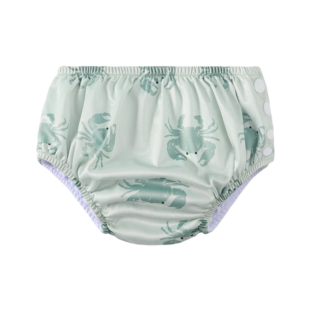 Reusable baby swim diaper in light green with crab pattern, featuring side snap closures.