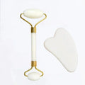 White jade facial roller and heart-shaped gua sha scraping tool for skincare massage.