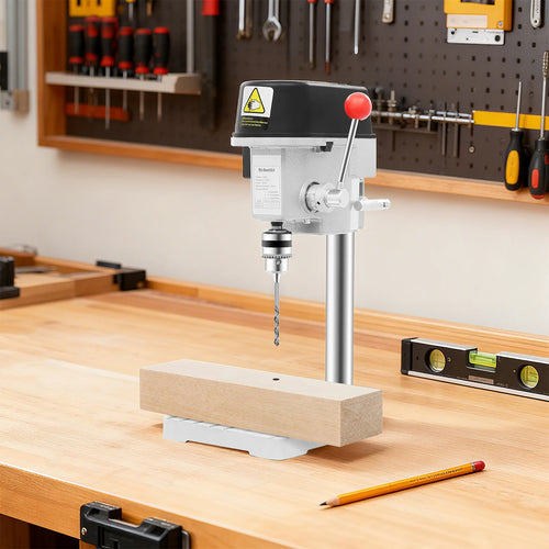 Mini electric bench drill press with black head and red handle, mounted on white base.