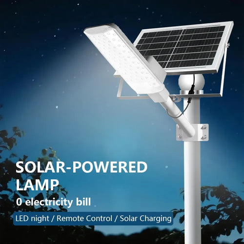 White solar street lamp with attached solar panel mounted on a pole, illuminating outdoors at night.