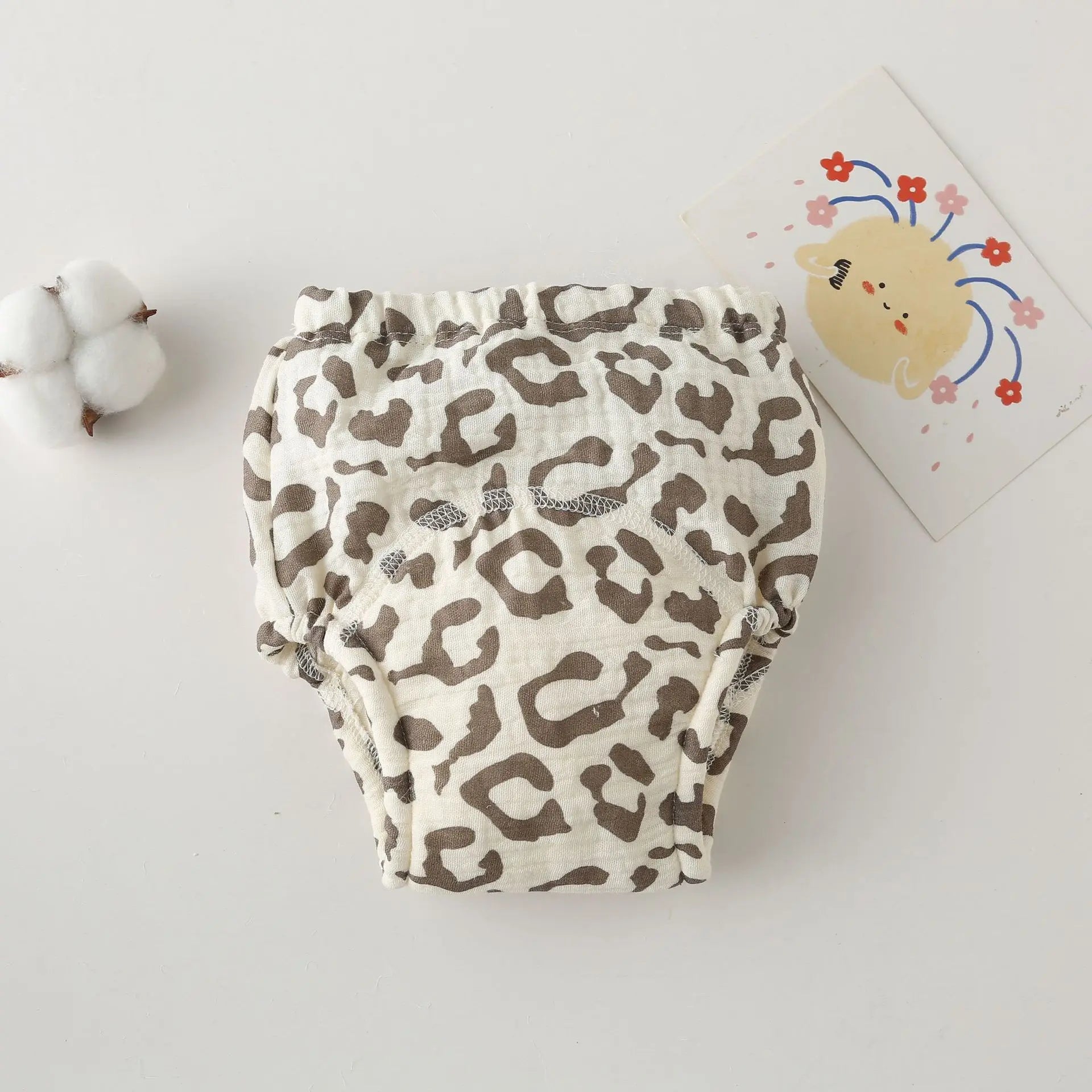 Baby diaper cover in a brown leopard print pattern, soft cotton fabric, stylish baby care essential.