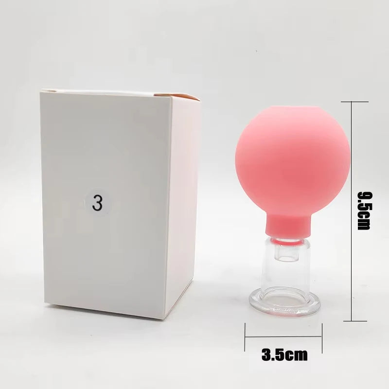 Pink rubber facial cupping bulb with a clear glass suction base next to a white box labeled with a "3".