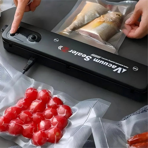 Black compact vacuum sealer with hands sealing vacuum bags for fish and meat