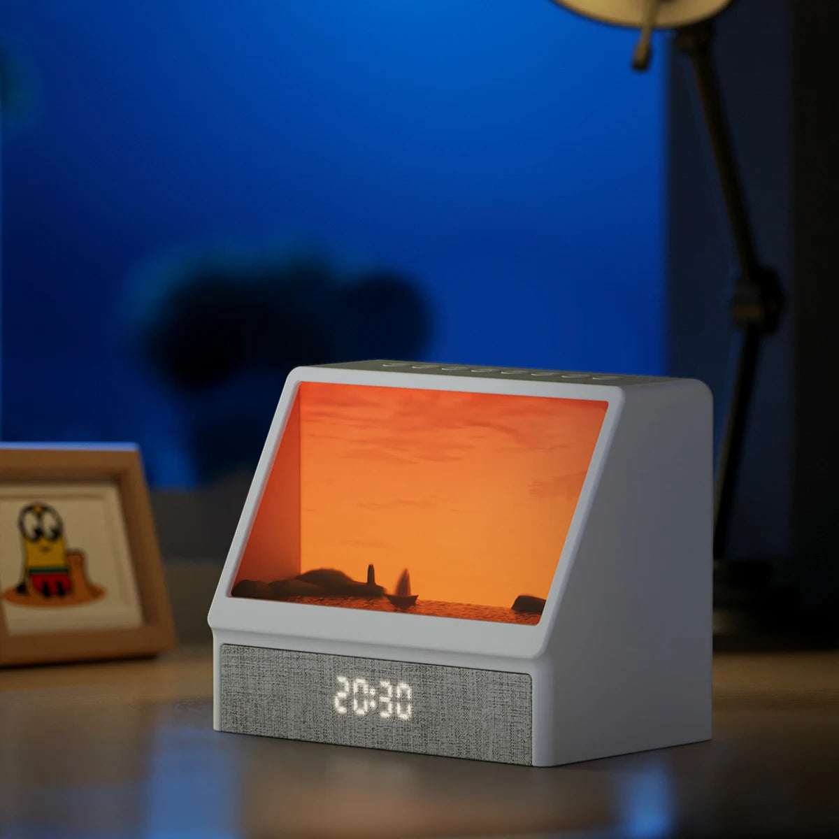 White sound machine for sleep featuring a white frame, digital clock display, top control buttons, and sunset night light.