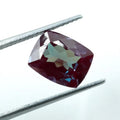 Faceted cushion-cut alexandrite gemstone, maroon-red with hints of teal color change
