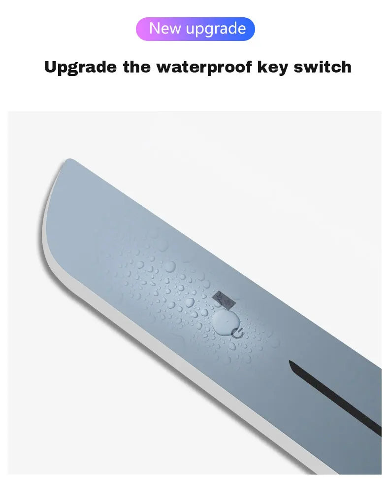 A matte grey, waterproof circular power button on a flat, rectangular surface, showing water droplets on the surface.