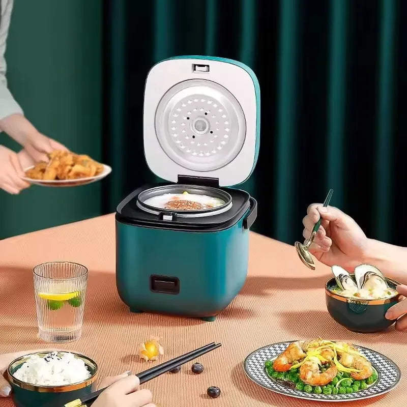 Mini electric rice cooker, teal pot open with lid and warm-ready meal bowl on tray