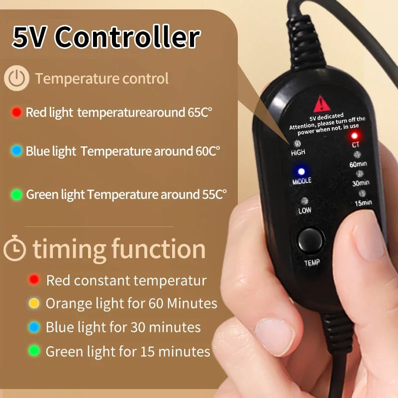 A hand holds a black 5V heating pad controller with temperature and timer settings indicated by colored LED lights.