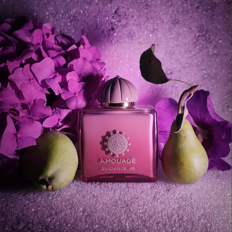 Amouage Guidance 46 perfume in a sleek pink gradient glass bottle, set with fresh pears and purple hydrangea flowers.