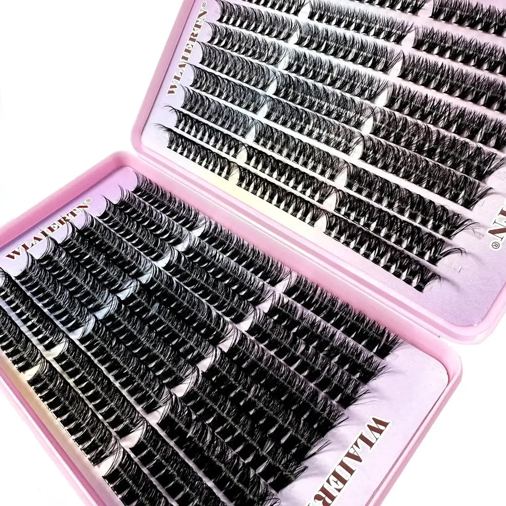 Set of individual black false eyelash clusters arranged in a pink plastic storage tray for professional eye makeup.