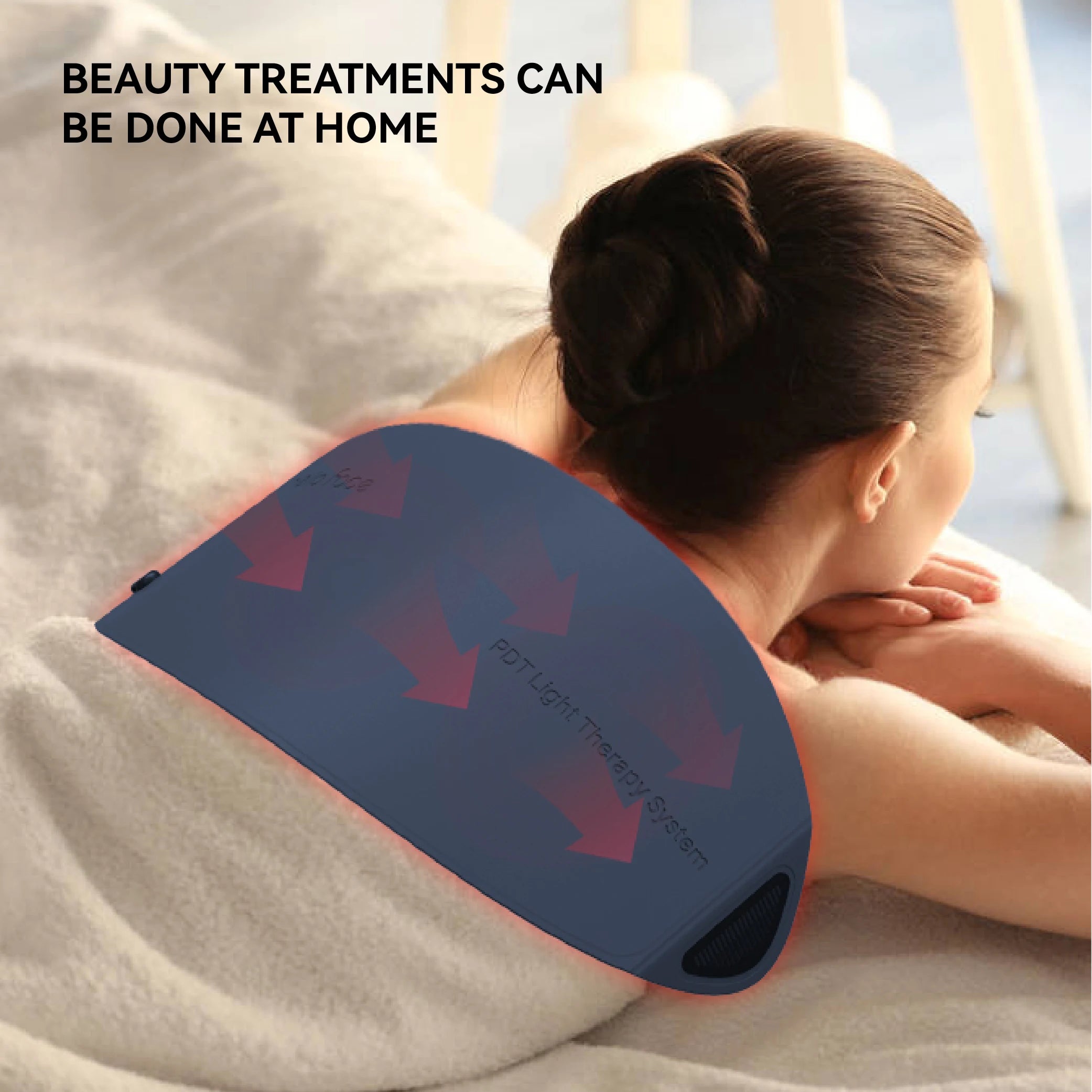 A woman lying on her back wearing a curved, dark blue PDT LED light therapy device on her upper back.