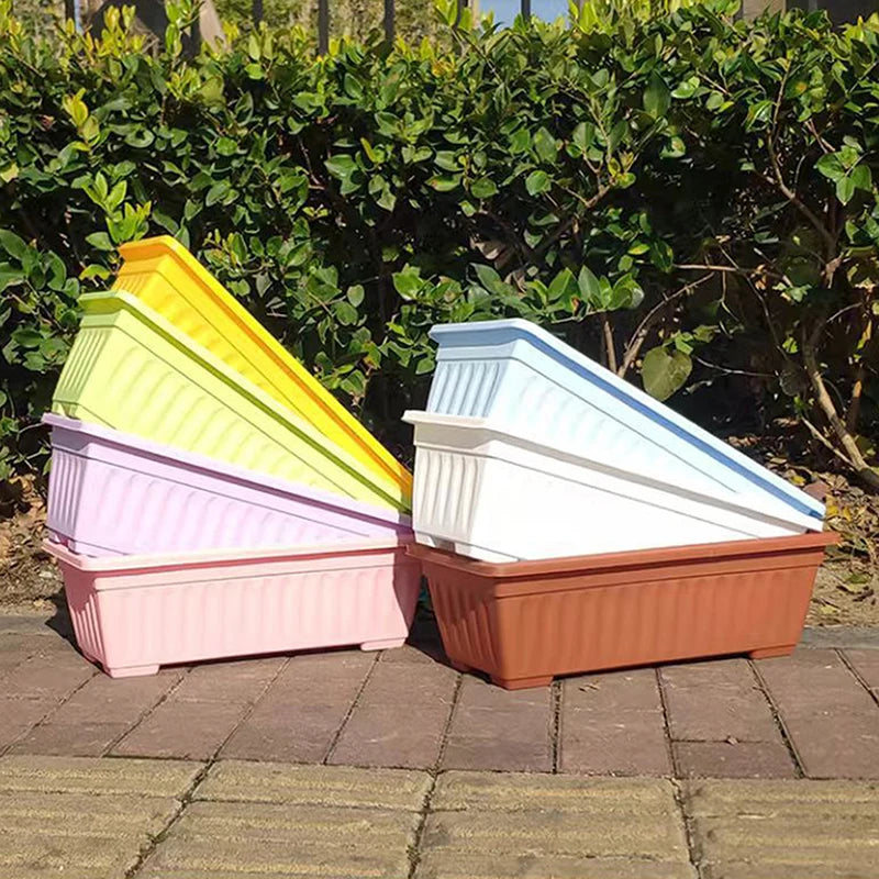 Rectangular plastic planters set in yellow, pink, white, and brown stacked outdoors