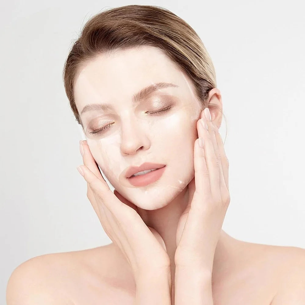 A woman with her eyes closed, applying a thin, transparent, moisture-locking facial mask sheet to her face.
